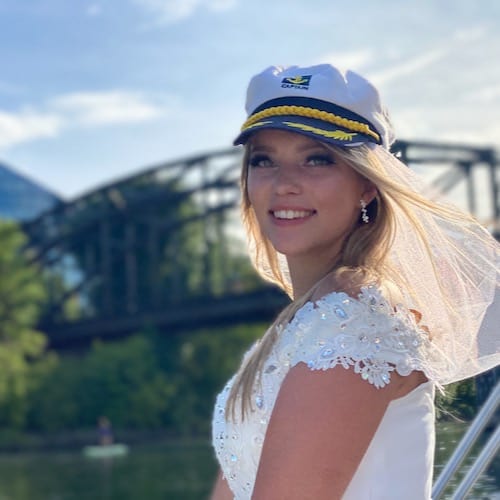 Braut mit Kapitänsmütze beim lenken des Partyboot in Frankfurt