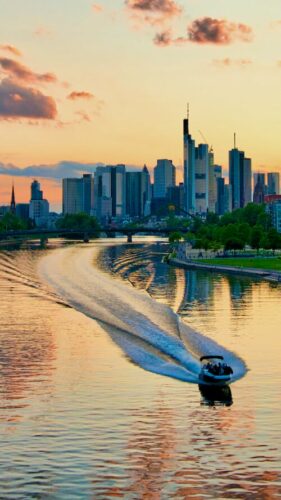 Schnelles Speedboot beim Sonnenuntergang vor der Skyline in Frankfurt