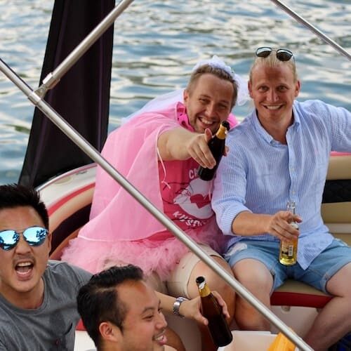 Männer bei einem coolen Junggesellenabschied mit Kostüm auf einem Partyboot