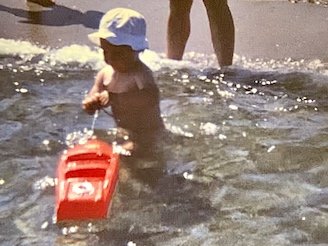 Captain Franky als Baby mit einem Spielzeugboot im Wasser