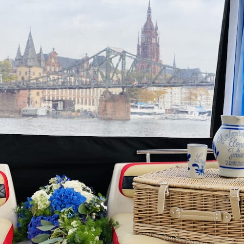Bembel, Apfelweinglas, Blumenstrauss dekoriert auf einem Boot mit Kaiserdom und Eisernen Steg und Historisches Museum im Hintergrund