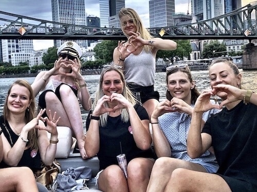 Eiserner Steg in Frankfurt mit Frauen auf einem Boot die ein Herz-Symbol machen